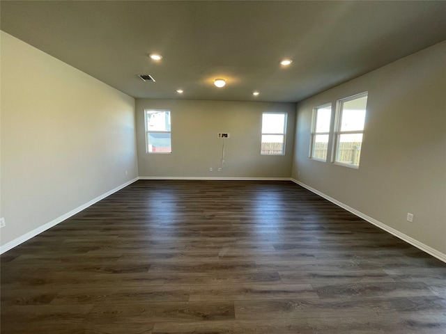 spare room featuring dark hardwood / wood-style floors and a wealth of natural light