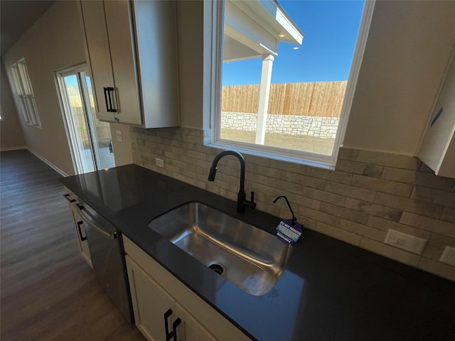 kitchen featuring sink, stainless steel dishwasher, dark hardwood / wood-style floors, and tasteful backsplash