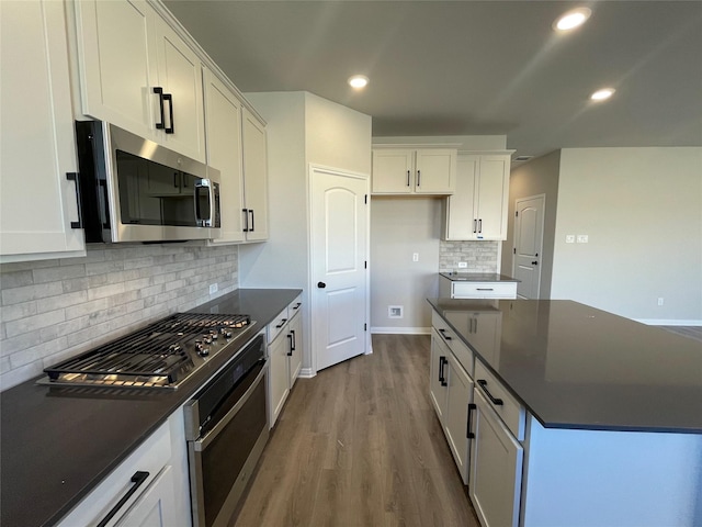 kitchen featuring appliances with stainless steel finishes, backsplash, and white cabinetry