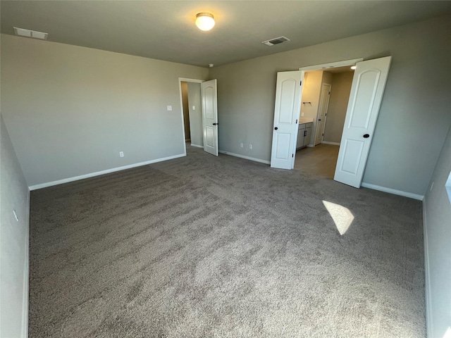 unfurnished bedroom with dark carpet