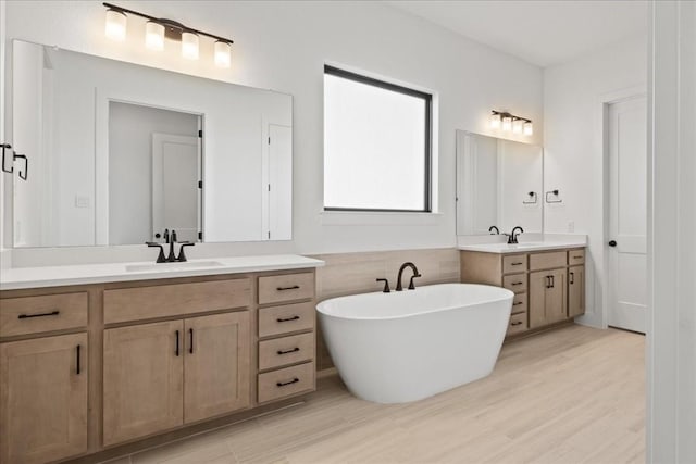 bathroom with a bathtub, vanity, and hardwood / wood-style flooring