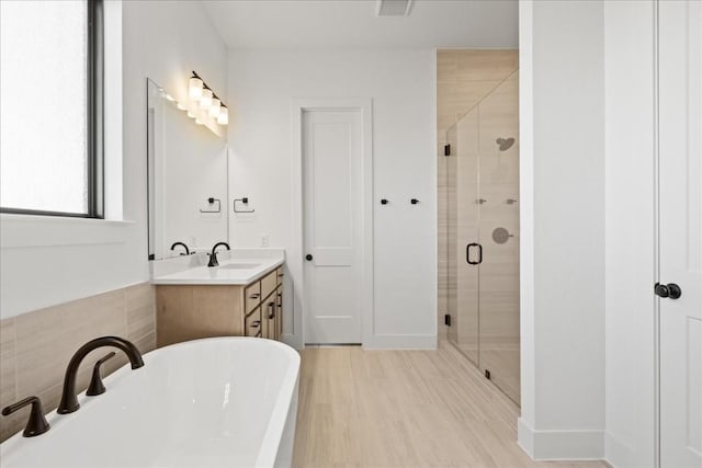 bathroom featuring hardwood / wood-style floors, vanity, and independent shower and bath