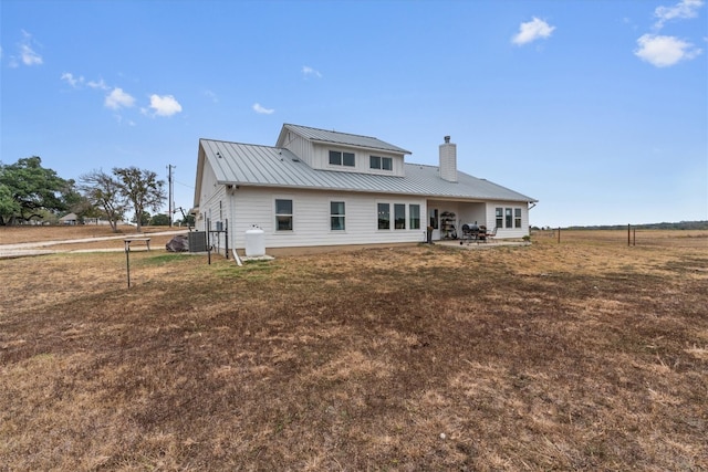 back of property with cooling unit and a yard