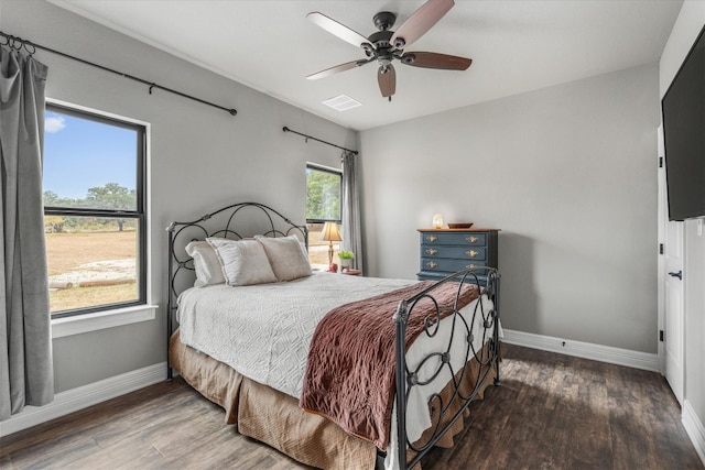 bedroom featuring multiple windows, hardwood / wood-style flooring, and ceiling fan