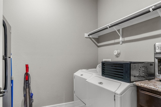 clothes washing area with washing machine and dryer