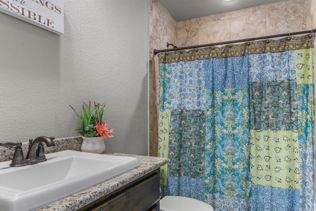 bathroom featuring a shower with shower curtain, sink, and toilet