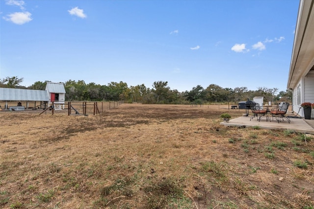 view of yard with a rural view and a patio area