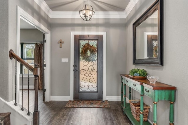 entrance foyer with dark wood-type flooring, a chandelier, and crown molding