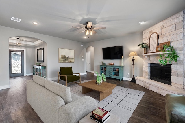 living room featuring a stone fireplace, hardwood / wood-style flooring, and ceiling fan