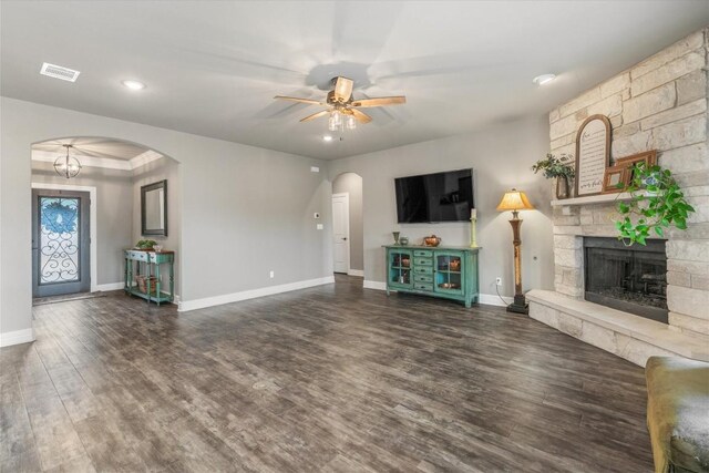 unfurnished living room with a fireplace, dark hardwood / wood-style floors, and ceiling fan