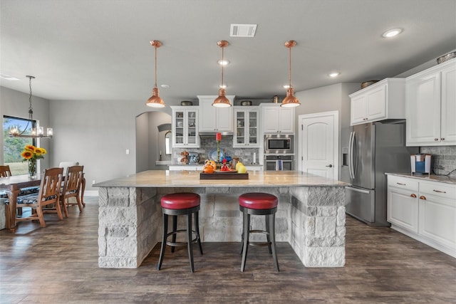 kitchen featuring stainless steel appliances, dark wood-type flooring, white cabinetry, and decorative light fixtures