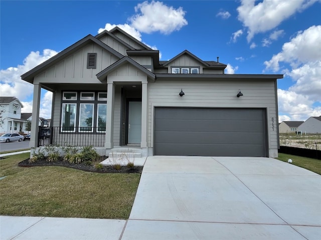 view of front of home featuring a garage, a front lawn, and covered porch