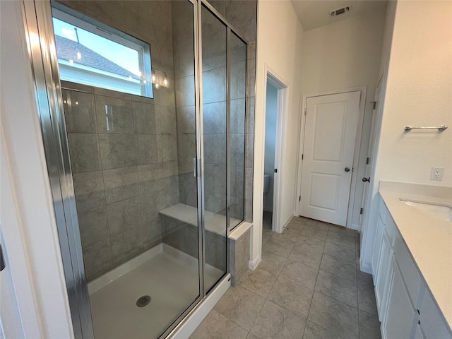 bathroom featuring tile patterned flooring, an enclosed shower, vanity, and toilet