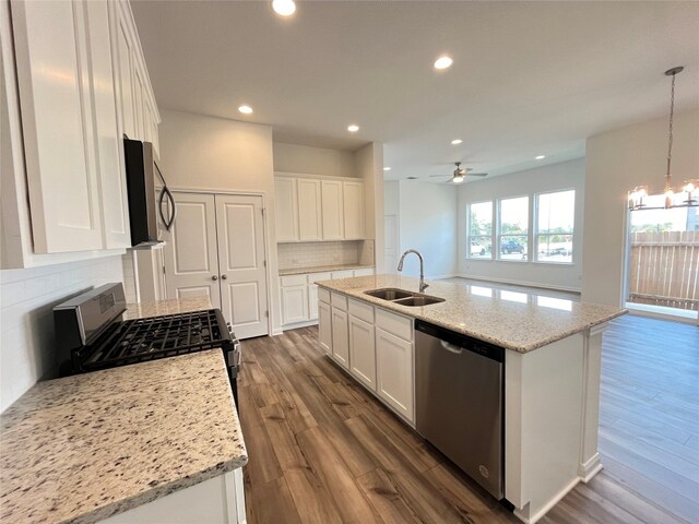 kitchen with white cabinetry, stainless steel appliances, and an island with sink