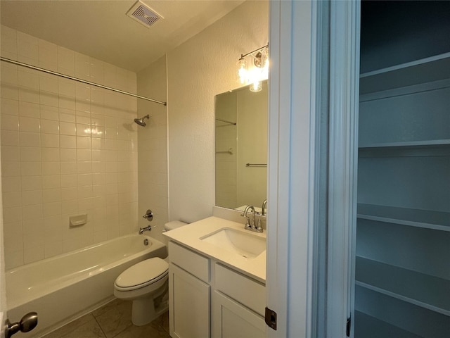 full bathroom with toilet, vanity, tiled shower / bath, and tile patterned flooring