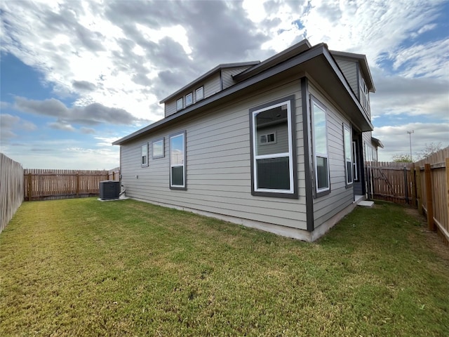 view of home's exterior with cooling unit and a yard