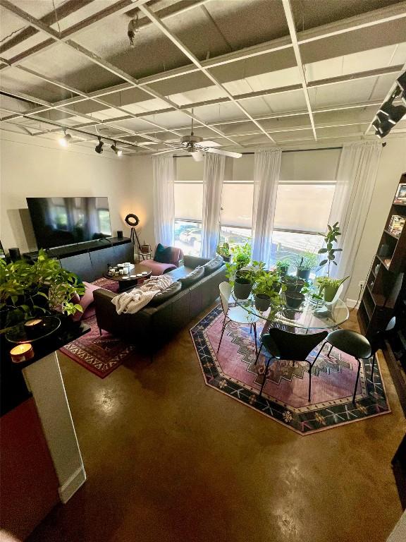 living room featuring ceiling fan and concrete floors