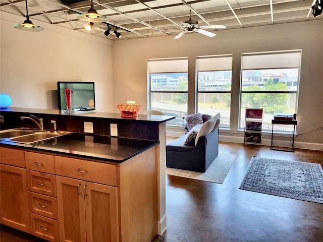 kitchen featuring decorative light fixtures, ceiling fan, and sink