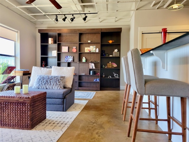 sitting room featuring ceiling fan and concrete flooring