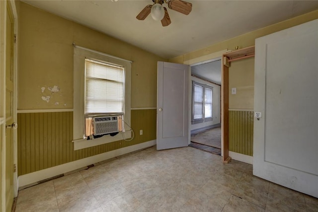 207 S Waco St, Giddings, TX 78942 - empty room featuring wainscoting, a ceiling fan, baseboards, and cooling unit
