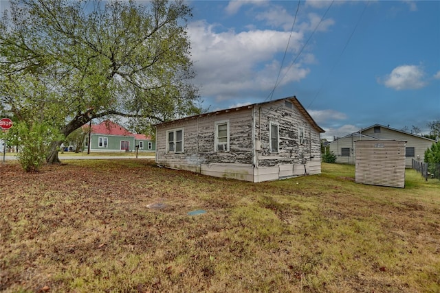 view of property exterior featuring a lawn and an outbuilding