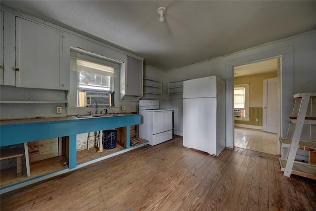 207 S Waco St, Giddings, TX 78942 - kitchen with freestanding refrigerator, hardwood / wood-style flooring, range with electric stovetop, and cooling unit