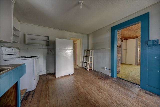 kitchen featuring hardwood / wood-style floors, white appliances, and white cabinetry