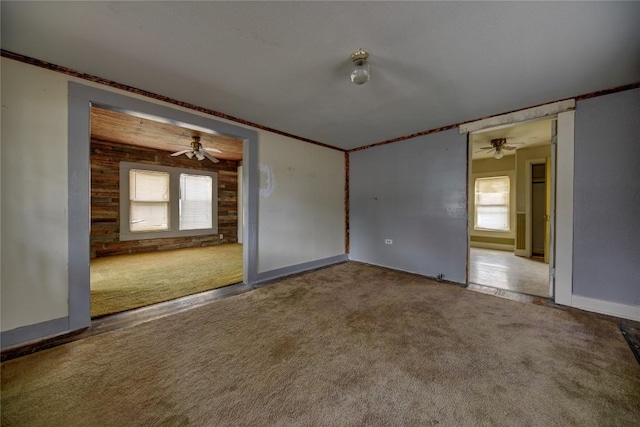 207 S Waco St, Giddings, TX 78942 - carpeted spare room with crown molding, ceiling fan, baseboards, and wooden walls