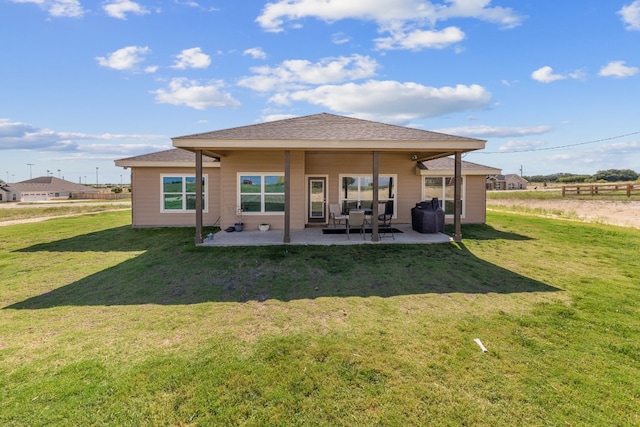 rear view of house featuring a lawn and a patio area