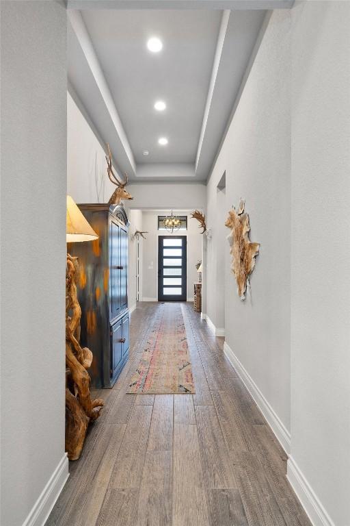 hallway featuring hardwood / wood-style flooring and a raised ceiling