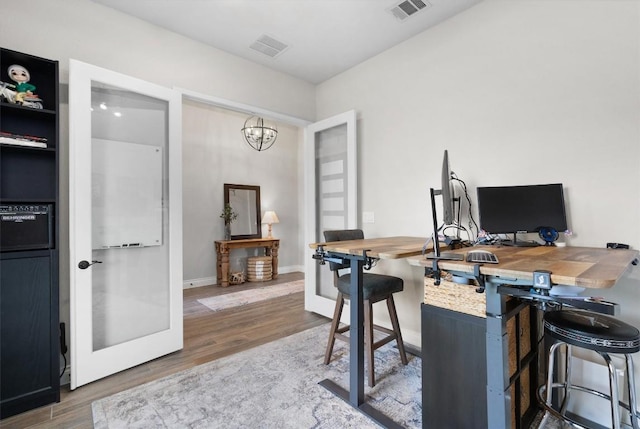 office space with wood-type flooring and a notable chandelier