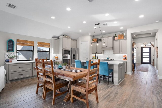 dining room featuring lofted ceiling and sink