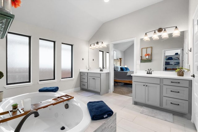 bathroom with tile patterned flooring, vanity, a relaxing tiled tub, and lofted ceiling