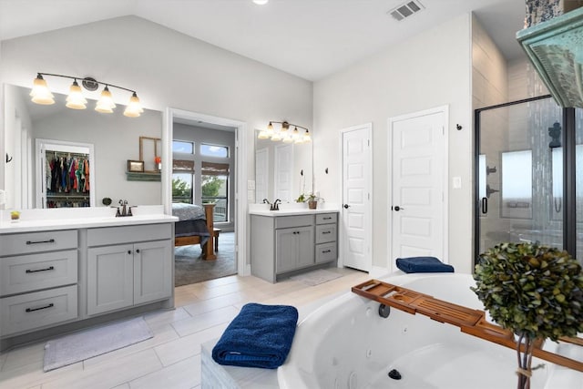 bathroom featuring tile patterned floors, vanity, separate shower and tub, and vaulted ceiling