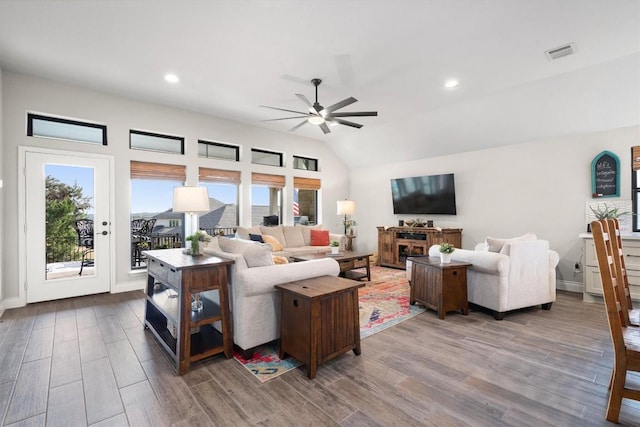 living room with lofted ceiling, ceiling fan, and a healthy amount of sunlight