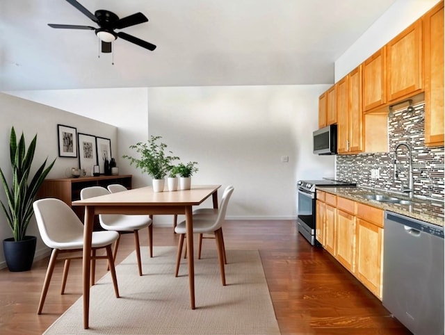 kitchen with light stone counters, sink, tasteful backsplash, dark hardwood / wood-style floors, and appliances with stainless steel finishes