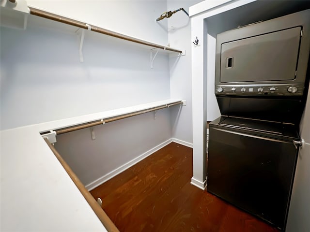 spacious closet with stacked washer / dryer and dark hardwood / wood-style floors