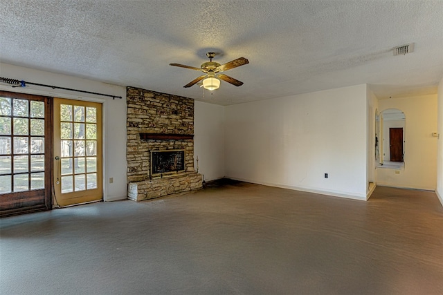 unfurnished living room with a fireplace, a textured ceiling, and ceiling fan