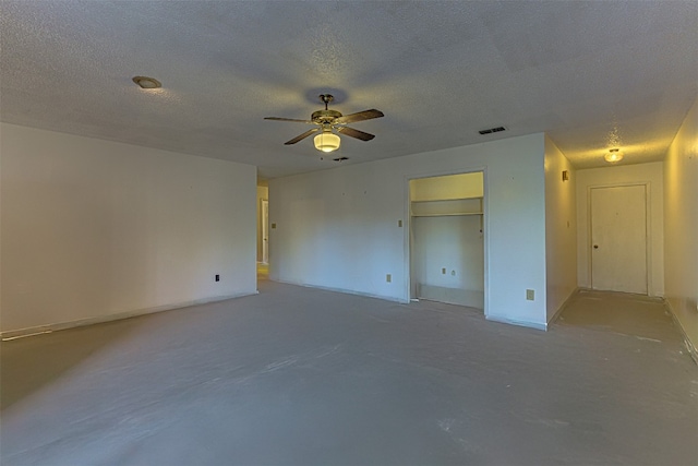 spare room with concrete flooring, a textured ceiling, and ceiling fan