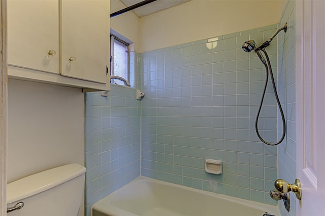 bathroom with tiled shower / bath and toilet