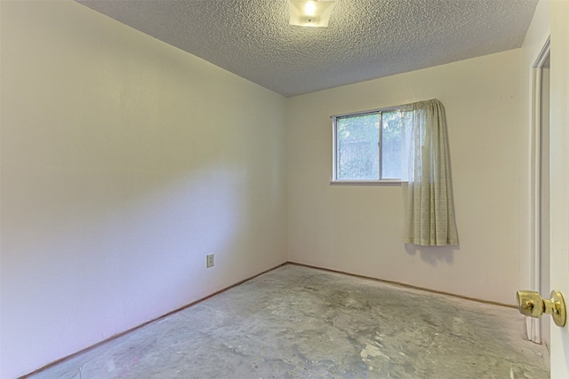 unfurnished room featuring a textured ceiling