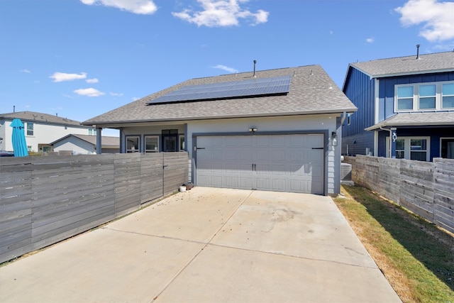 view of front of home with a garage and solar panels