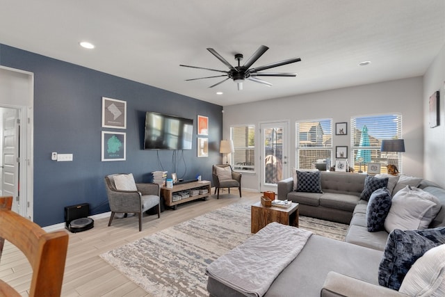 living room with light hardwood / wood-style floors and ceiling fan