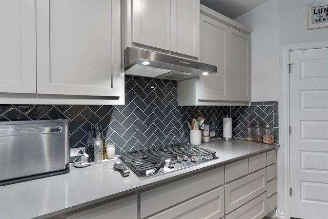 kitchen with decorative backsplash, exhaust hood, and stainless steel gas stovetop