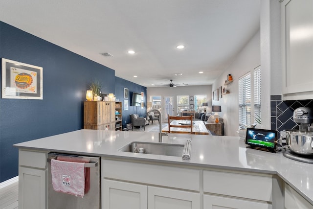 kitchen with white cabinetry, stainless steel dishwasher, sink, and ceiling fan