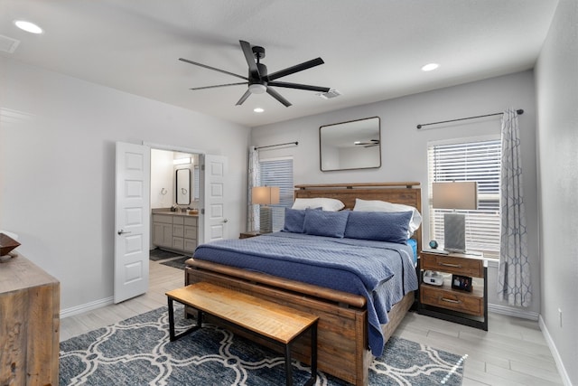 bedroom with ensuite bathroom, light wood-type flooring, ceiling fan, and sink