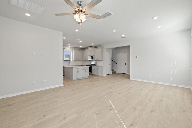 unfurnished living room with ceiling fan and light hardwood / wood-style flooring