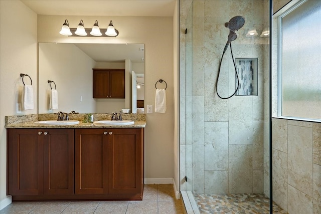 bathroom featuring a tile shower, vanity, and tile patterned floors