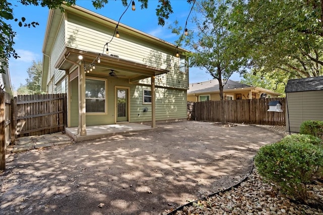 rear view of property featuring ceiling fan and a patio area