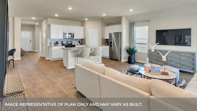 living room with light hardwood / wood-style floors and sink